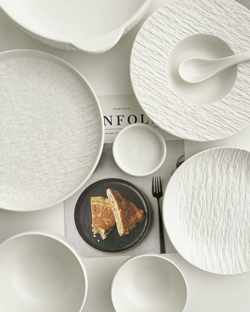 White ceramic bowls and plates arranged for a meal