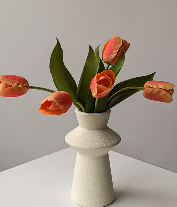 Cream ceramic vase with orange tulips